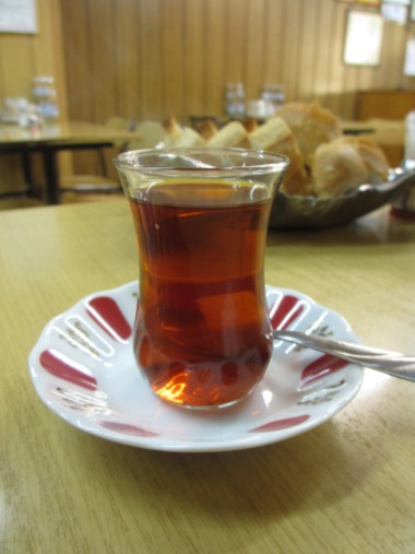 saucer with glass of Turkish tea, dark liquid