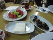 white plates with tomatoes, cucumber, plate of white cheese, plate of marinated olives