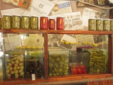 shop display with bottles of vegetables, plastic containers of vegetables in liquid