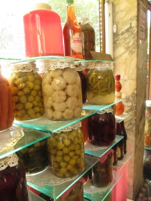 window display, bottles of vegetables in liquid, on display shelves