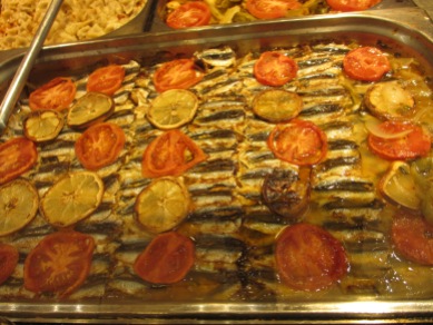 rows of small fish, layered with slices of lemon and tomato