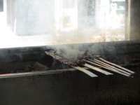 metal skewers with smoke cooking over a coal fire