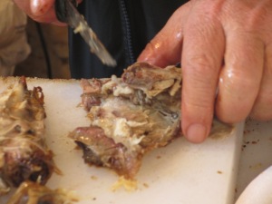 man's hand and knife pulling meat apart