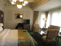 king sized bed and sitting area in suite hotel in Istanbul