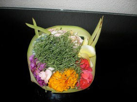 banana leaves folded into a bowl with flowers and Hindu offerings